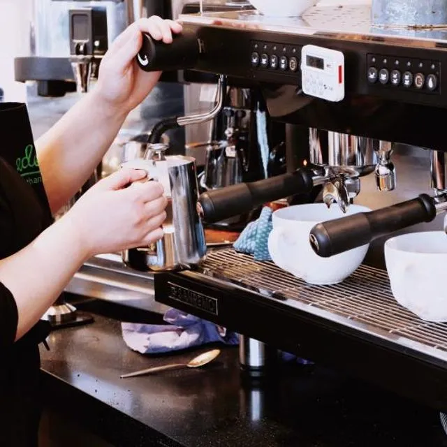 Les mains d’un barista préparent un café au comptoir