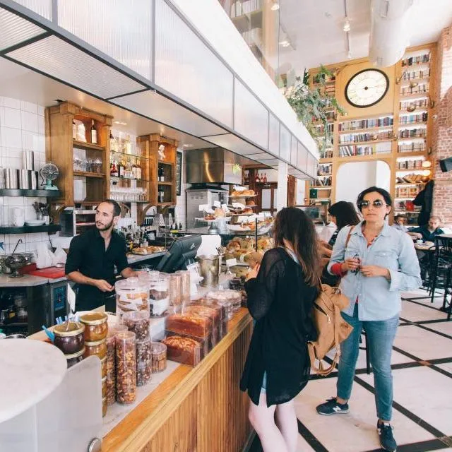 Un comptoir de café-boulangerie, clients et équipe au service
