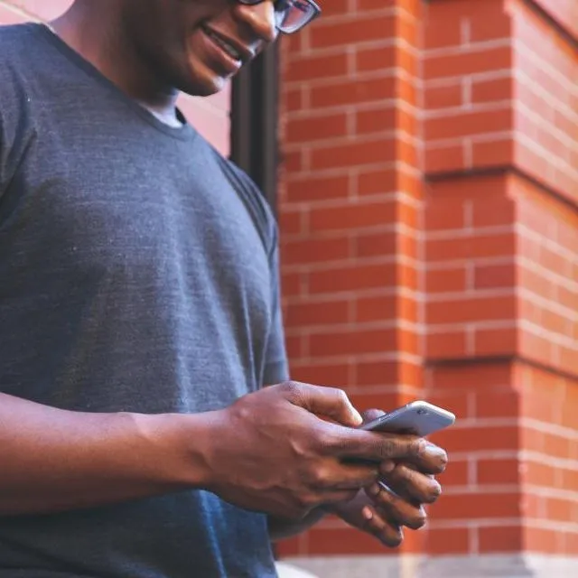 Un homme réserve sur son téléphone, dans la rue